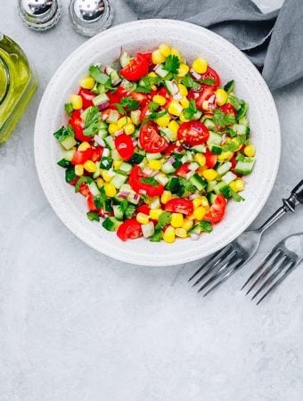 Fresh Summer Corn and tomato saldSalad Bowl With Tomatoes, Cucumbers, Red Onions And Parsley.