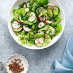 Tender mixed greens salad with cucumber, radishes, and herbs